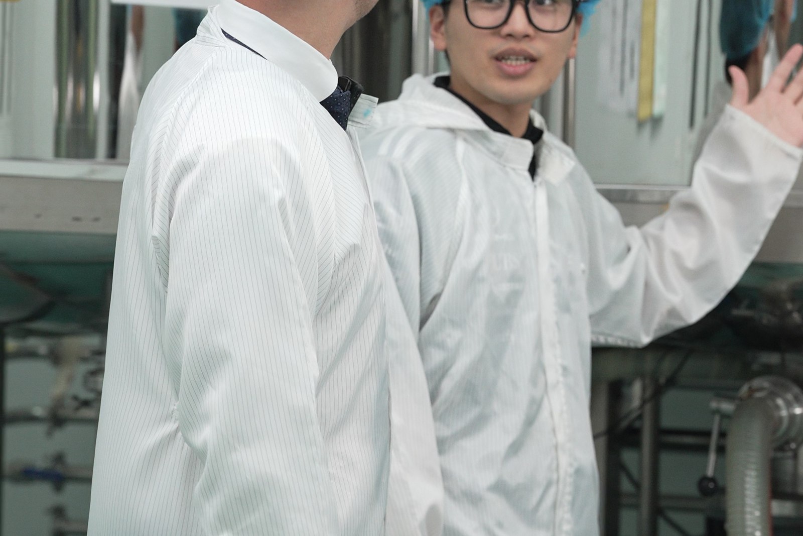 Production staff working beside stainless-steel processing vessels